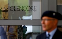 An employee of a private security company stands in front of the logo of commodities trader Glencore during the company's annual shareholder meeting in Cham, Switzerland May 24, 2017. REUTERS/Arnd Wiegmann