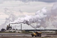 Alberta is preparing to change how it ensures oilsands companies are able to pay for the mammoth job of cleaning up their operations, but critics fear a year of consultations hasn't been enough to avoid repeating past mistakes. A dump truck works near the Syncrude oilsands extraction facility near the city of Fort McMurray, Alberta on Sunday June 1, 2014. THE CANADIAN PRESS/Jason Franson