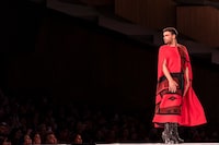 This photo taken on November 20, 2023 shows a model for Rebecca Baker-Grenier taking the runway during the Red Dress Event of the Vancouver Indigenous Fashion Week at Queen Elizabeth Theatre in Vancouver. (Photo by Paige Taylor White / AFP) (Photo by PAIGE TAYLOR WHITE/AFP via Getty Images)