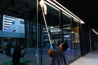 A sign board displays the TSX level as a custodian cleans windows in the financial district in Toronto on Wednesday, September 29, 2021. THE CANADIAN PRESS/Evan Buhler