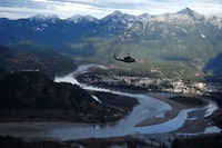 One of the three Royal Canadian Air Force helicopters surveys the Fraser Valley after rainstorms lashed the western Canadian province of British Columbia, triggering landslides and floods, shutting highways, near Abbotsford, B.C., Sunday, Nov. 21, 2021. The British Columbia government says a new $20-million flood mitigation program for the Fraser Valley will help support farmers and food resiliency in prime agricultural areas that were inundated by floodwaters in November 2021. THE CANADIAN PRESS/Jennifer Gauthier, POOL