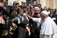 Pope Francis greets a child as he attends the weekly general audience in St. Peter's Square at the Vatican, May 31, 2023.   Vatican Media/­Handout via REUTERS    ATTENTION EDITORS - THIS IMAGE WAS PROVIDED BY A THIRD PARTY.