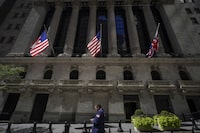 A trader looks over his cell phone outside the New York Stock Exchange, Wednesday, Sept. 14, 2022.