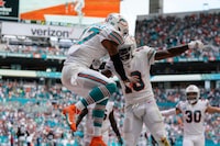 Miami Dolphins wide receiver Jaylen Waddle (17) celebrates with wide receiver Tyreek Hill (10) after scoring a touchdown during the second half of an NFL football game against the New England Patriots, Sunday, Oct. 29, 2023, in Miami Gardens, Fla. (AP Photo/Wilfredo Lee)