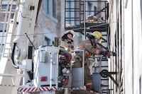MONTREAL, Que. (19/03/2023) - Firefighters begin to dismantle the remains of the fire in Place d'Youville on March 19, 2023, in Montreal, QC. The fire left the historic building destroyed, with firefighters now looking to dismantle it. (Andrej Ivanov/The Globe and Mail)