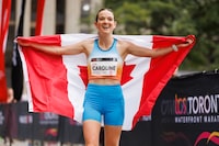 TORONTO, CANADA - OCTOBER 15: Caroline Pomerleau of Canada poses with a Canadian flag after winning the Canadian Women's category of the Toronto Waterfront Marathon on October 15, 2023 in Toronto, Canada. (Photo by Cole Burston/Getty Images)