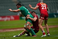 Ireland's Chay Mullins, left, is tackled by Canada's Phil Berna during the 9th place quarterfinal match of the Hong Kong Sevens rugby tournament in Hong Kong, Sunday, April 2, 2023. While Argentina looks to join New Zealand in securing a berth at the 2024 Paris Olympics, the battle at the other end of the HSBC World Rugby Sevens Series standings will add more drama to the penultimate stop of the men's season in France this weekend. The Canadian men are in the thick of it, facing a relegation fight.THE CANADIAN PRESS/AP/Louise Delmotte