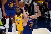 Denver Nuggets center Nikola Jokic (15) shoots as Los Angeles Lakers forward LeBron James (6) looks on during the second half of Game 1 of the NBA basketball Western Conference Finals series, Tuesday, May 16, 2023, in Denver. (AP Photo/David Zalubowski)