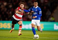 Doncaster Rovers' Jack Senior, left, battles for the ball with Everton's Lewis Dobbin during the Carabao Cup second round match at the Eco-Power Stadium in Doncaster, England, Wednesday Aug. 30, 2023. (Mike Egerton/PA via AP)