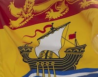 Police say a man who was in a Saint John, N.B., detention facility has died. New Brunswick's provincial flag flies in Ottawa on Friday July 3, 2020. THE CANADIAN PRESS/Adrian Wyld