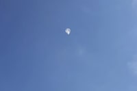 In this image taken from a video shot by Tom Medlin on June 11, 2022, a pico balloon, which costs about $12 and is about 32 inches in diameter, floats in the air near Collierville, Tenn. Medlin, owner of the Amateur Radio Roundtable podcast, believes a similar balloon is what the U.S. military shot down over the Yukon recently. Hobbyists typically fly the balloons for fun and to experience the challenge of building transmitters and antenna systems, although the National Oceanic and Atmospheric Administration has been collecting data from operators to learn more about wind patterns, he said. (Tom Medlin via AP)