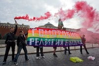 FILE - Gay rights activists hold a banner reading "Homophobia - the religion of bullies" during their action in protest at homophobia, on Red Square in Moscow, Russia, on July 14, 2013. Russian lawmakers on Wednesday June 14, 2023 approved in first reading a bill outlawing gender-affirming medical care and changing gender in official documents in yet another crippling blow to Russia's already beleaguered LGBTQ+ community. (AP Photo/Evgeny Feldman, File)