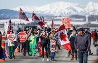 Anti-carbon tax protesters wave signs and chant slogans as they block a westbound lane of the Trans Canada highway near Cochrane, Alta., Monday, April 1, 2024.THE CANADIAN PRESS/Jeff McIntosh