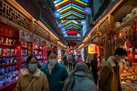 FILE - Visitors look at shops selling trinkets and souvenirs along a tourist shopping street in Beijing, Feb. 28, 2023. Asian economies are not doing as well as they could and growth in the region is forecast to slow to 4.5% this year from 5.1% in 2023, the World Bank said in a report released Monday, April 1, 2024.(AP Photo/Mark Schiefelbein, File)