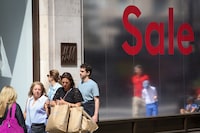 FILE PHOTO: Shoppers walk past a sale sign on Oxford Street, Britain is struggling with the highest inflation rate among the world's big rich economies, London, Britain, 17 July 2023. REUTERS/Rachel Adams/File Photo