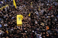 Hezbollah fighters carry the coffin of their comrade, Mohammed Ali Assaf, who was killed by an Israeli strike in Syria Friday morning, during his funeral procession in the southern Beirut suburb of Dahiyeh, Lebanon, Saturday, Nov. 11, 2023. Lebanon's militant Hezbollah group has announced the death of seven of its fighters without giving details on where they were killed. A Hezbollah official and a Lebanese security official said the seven fighters were killed in neighboring Syria Friday morning. (AP Photo/Hassan Ammar)