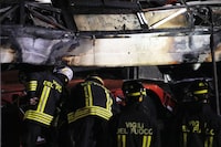 Italian firefighters work at the scene of a passenger bus accident in Mestre, near the city of Venice, Italy, Wednesday, Oct. 4, 2023. The bus fell from an elevated road, late Tuesday, killing multiple people. (AP Photo/Antonio Calanni)