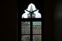 The federal inquiry into foreign interference says its initial hearings will help identify ways to make information public even though much of it will originate from classified documents and sources.The Confederation Building is pictured through a window on Parliament Hill in Ottawa on Tuesday, Nov. 7, 2023. THE CANADIAN PRESS/Sean Kilpatrick