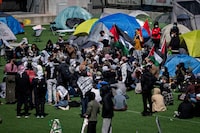 A pro-Palestinian activist group that has been promoting a protest encampment at the University of B.C. says its international co-ordinator was arrested and released with an order not to attend any protests for the next five months. People gather and pitch tents at a pro-Palestinian student encampment at the University of British Columbia campus in Vancouver, Monday, April. 29, 2024. THE CANADIAN PRESS/Ethan Cairns