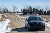 A RCMP vehicle secures the driveway of a home north east of Neudorf, Saskatchewan on Tuesday, March 26, 2024. Black unmarked RCMP vehicles could be seen blocking roads leading to a Saskatchewan farm property as officers continued to investigate the suspicious deaths of four people. THE CANADIAN PRESS/Liam Richards

