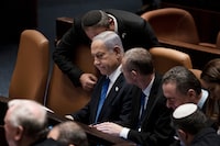 Israel's Prime Minister Benjamin Netanyahu, center, is surrounded by lawmakers at a session of the Knesset, Israel's parliament, in Jerusalem, Israel, Monday, July 24, 2023. (AP Photo/Maya Alleruzzo)
