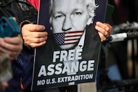 FILE PHOTO: A supporter of WikiLeaks founder Julian Assange holds a sign, on the day the High Court is set to rule on whether Julian Assange can appeal against extradition from Britain to the United States, in London, Britain, March 26, 2024. REUTERS/Toby Melville/File Photo