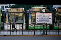A man walks past parked buses on May 9, 2024, in Buenos Aires, during a general strike called by the General Confederation of Labor (CGT).  . Argentina's President Javier Milei faces this Thursday the second general strike against the "brutal adjustment" of his government, which paralyzes land, sea, and air transportation services as well as educational, financial, and commercial institutions throughout the country. (Photo by Luis ROBAYO / AFP) (Photo by LUIS ROBAYO/AFP via Getty Images)