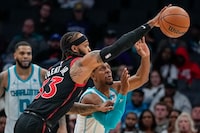 Toronto Raptors guard Gary Trent Jr. and Charlotte Hornets guard Ish Smith battles for a loose ball during the second half of an NBA basketball game Friday, Dec. 8, 2023, in Charlotte, N.C. (AP Photo/Chris Carlson)