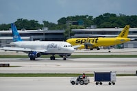 FILE - A JetBlue Airways Airbus A320, left, passes a Spirit Airlines Airbus A320 as it taxis on the runway, July 7, 2022, at the Fort Lauderdale-Hollywood International Airport in Fort Lauderdale, Fla. JetBlue Airways warned Friday, Jan. 26, 2024, that it might end its attempt to buy low-cost carrier Spirit Airlines as soon as this weekend, sending Spirit shares lower. (AP Photo/Wilfredo Lee, File)