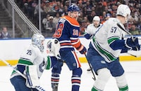 Vancouver Canucks' goalie Casey DeSmith (29) makes the save as Edmonton Oilers' Zach Hyman (18) looks for the rebound during second period NHL action in Edmonton, Saturday, April 13, 2024. THE CANADIAN PRESS/Jason Franson 