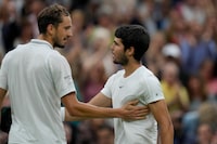 Spain's Carlos Alcaraz, right, greets Russia's Daniil Medvedev after beating him to win their men's singles semifinal match on day twelve of the Wimbledon tennis championships in London, Friday, July 14, 2023. (AP Photo/Alastair Grant)