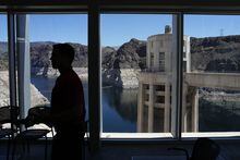 FILE - People attend a news conference on Lake Mead at Hoover Dam, April 11, 2023, near Boulder City, Nev. Arizona, California and Nevada on Monday, May 22, proposed a deal to significantly cut their water use from the drought-stricken Colorado River over the next three years. (AP Photo/John Locher, File)