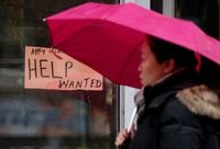 A woman walks past a help wanted sign in Ottawa, on Nov. 2, 2017.