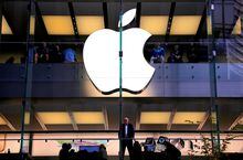 FILE PHOTO: A customer stands underneath an illuminated Apple logo as he looks out the window of the Apple store located in central Sydney, Australia, May 28, 2018. REUTERS/David Gray/File Photo/File Photo