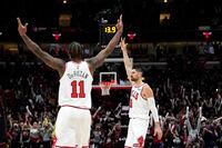 Chicago Bulls' Nikola Vucevic (9) and DeMar DeRozan celebrate Vucevic's three-point basket with 13.9 second remaining in the second half of an NBA basketball game against the Toronto Raptors Wednesday, Jan. 26, 2022, in Chicago. The Bulls won 111-105. (AP Photo/Charles Rex Arbogast)