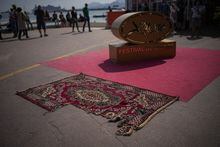 A rug, damaged by a bomb in the town of Lukashivka in Ukraine brought by the crew of the documentary film "In the Rearview", is pictured on Boulevard de la Croisette during the 76th edition of the Cannes Film Festival in Cannes, southern France, Sunday, May 21, 2023. (AP Photo/Daniel Cole)