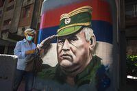 A woman walks past a mural depicting former Bosnian Serb military chief Ratko Mladic, in Belgrade on June 8, 2021. - International judges will give their verdict on June 8, 2021 on an appeal by former Bosnian Serb military chief Ratko Mladic against his genocide conviction over the 1995 Srebrenica massacre, a UN court said on June 4, 2021. Mladic was sentenced to life in prison in 2017 for overseeing the massacre of some 8,000 Muslim men and boys, and for war crimes and crimes against humanity in general during the 1992-95 Bosnian war. (Photo by Andrej ISAKOVIC / AFP) (Photo by ANDREJ ISAKOVIC/AFP via Getty Images)