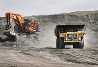A haul truck carrying a full load drives away from a mining shovel at the Shell Albian Sands oil sands mine, near Fort McMurray, Alta., on July 9, 2008.