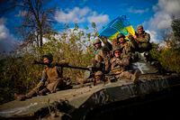 Ukrainian soldiers sit on an armoured vehicle as they drive on a road between Izium and Lyman in Ukraine, Tuesday Oct. 4, 2022. (AP Photo/Francisco Seco)