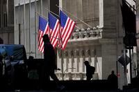 In this Oct. 14, 2020 file photo, pedestrians pass the New York Stock Exchange.