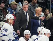 Toronto Maple Leafs coach Sheldon Keefe talks to player during the second period of the team's NHL hockey game against the Colorado Avalanche on Saturday, Dec. 31, 2022, in Denver. (AP Photo/David Zalubowski)