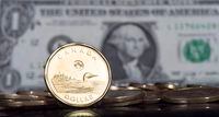 The Canadian dollar coin, the Loonie, is displayed next to the US dollar Friday, January 30, 2015 in Montreal. THE CANADIAN PRESS/Paul Chiasson