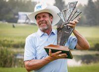 Doug Barron, right, of the United States, holds the trophy after winning the PGA Tour Champion's Shaw Charity Classic golf event in Calgary, Alta., Sunday, Aug. 15, 2021.THE CANADIAN PRESS/Jeff McIntosh