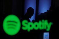 FILE PHOTO:  A trader is reflected in a computer screen displaying the Spotify brand before the company begins selling as a direct listing on the floor of the New York Stock Exchange in New York, U.S., April 3, 2018.  REUTERS/Lucas Jackson/File photo