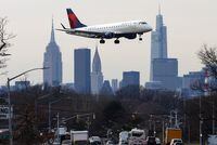 A Delta Airlines jet comes in for a landing in front of the Empire State Building and Manhattan skyline after flights earlier were grounded during an FAA system outage at Laguardia Airport, in New York City, New York, U.S., January 11, 2023. REUTERS/Mike Segar