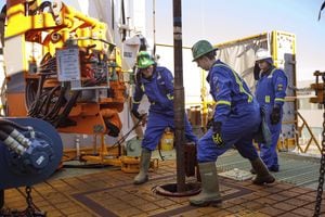 Precision Drilling Corp. Trainees Dan Brook and Bradley Williams are directed by instructor Clint Dyck while training to lay down drill pipe on a rig floor, at Precision Drilling in Nisku, Alta., on January 20, 2016.
