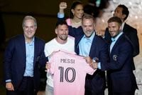 Inter Miami's Lionel Messi, center left, holds his new Inter Miami team jersey as he poses with team co-owners Jorge Mas, left, Jose Mas, second right, and David Beckham during a celebration by the team at DRV PNK Stadium, Sunday, July 16, 2023, in Fort Lauderdale, Fla. It comes one day after Messi, Major League Soccer and Inter Miami finalized his signing through the 2025 season. His first official training session is Tuesday and he is expected to play Friday in a Leagues Cup match against Cruz Azul. (AP Photo/Rebecca Blackwell)
