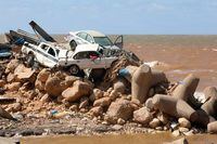 TOPSHOT - Cars are piled up atop wave breakers and the rubble of a building destroyed in flash floods after the Mediterranean storm "Daniel" hit Libya's eastern city of Derna, on September 14, 2023. A global aid effort for Libya gathered pace on September 14 after a tsunami-sized flash flood killed at least 4,000 people, with thousands more missing, a death toll the UN blamed in part on the legacy of years of war and chaos. (Photo by Abdullah DOMA / AFP) (Photo by ABDULLAH DOMA/AFP via Getty Images) *** BESTPIX ***