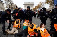 French police remove environmental activists of "Derniere Renovation" (Last Renovation) group from the road as they block the traffic on the Champs Elysees avenue near the Arc de Triomphe in Paris to draw attention to environmental issues on housing and building renovation during the energy crisis in France, France, December 8, 2022.  REUTERS/Gonzalo Fuentes