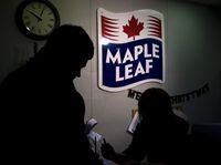 A Maple Leaf Foods employee, right, signs in a person at the company's meat facility in Toronto on December, 15, 2008. THE CANADIAN PRESS/Nathan Denette
